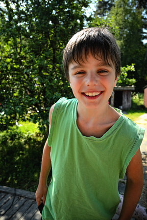 Closeup portrait cute little boy smiling in a parkの写真素材