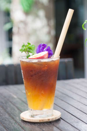 Passion fruit coffee is a delicious drink in a clear glass with cold ice in a glass decorated with colorful passion fruit and butterfly pea flowers.の写真素材