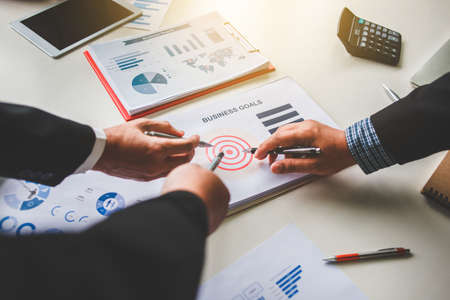 Business team together pointing to business goals, business goal concept