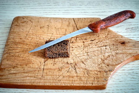 An old rugged cutting board and a spent knife