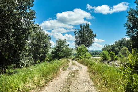 rural road outside the city summer blue sky cloudsの写真素材