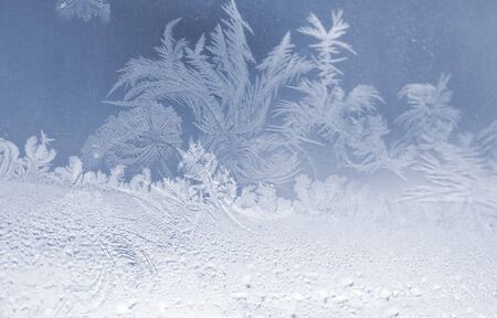 Beautiful natural frosty snowflakes on the window glass