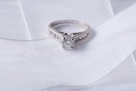 Single sparkling diamond ring with white ribbon の写真素材