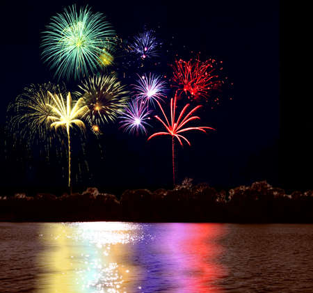 Colorful fireworks reflecting on the lakeの写真素材