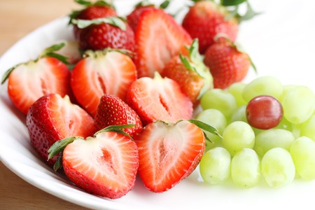 Fresh, red strawberry and green grapes on plateの写真素材