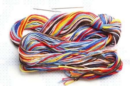 Bundle of colorful embroidery threads on stamped cross stitch