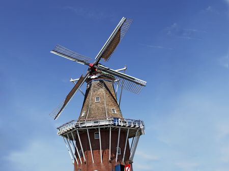 Old working Dutch windmill against blue skyの写真素材