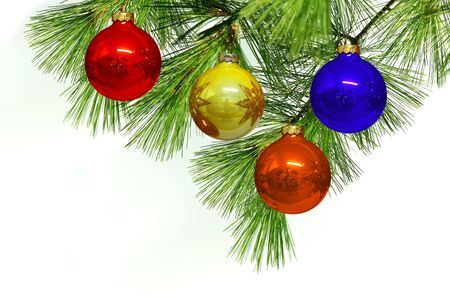 Christmas ball hanging over pine branch isolated on whiteの写真素材