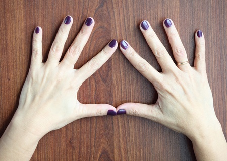 Middle aged woman hands with shellac manicure over wooden background wearing wedding ring