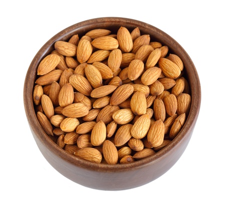 Wooden bowl of almonds isolated on whiteの写真素材