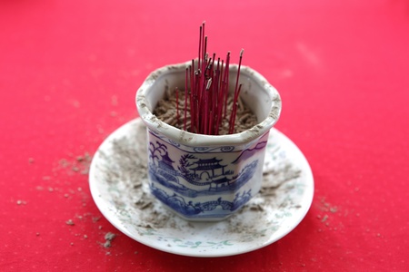 Burnt joss incense sticks in the holderの写真素材