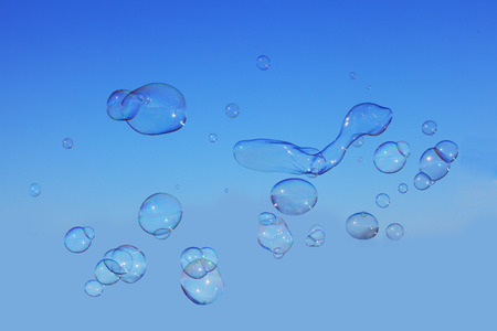 Soap bubbles floating over blue sky in spring timeの写真素材