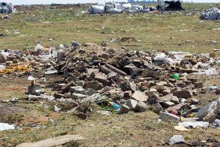 stock photo of building rubble and garbage collection bags and other plastic objects and trash at  waste disposal site  lying around and littering waste disposal site, no organised effort, roughly strewn around, just dumped waste,のeditorial素材