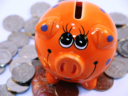 Bunch of Latvian lat coins and piggy bank on white backgroundの写真素材