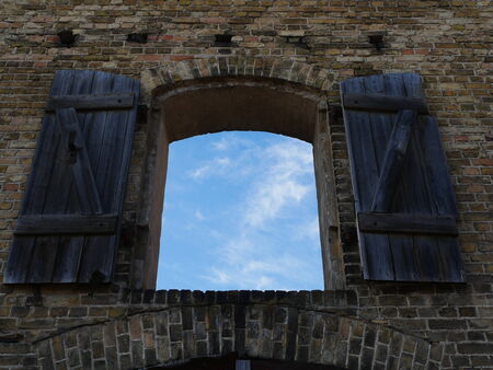 Arched wooden window overlooking the sky in rigaの写真素材