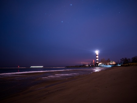 Black and white lighthouse at night in Baltic sea beach with starsの写真素材