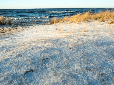 Beautiful view of winter frozen desert dunes on seashore of Baltic sea in Latviaの写真素材