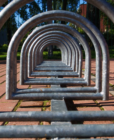 Metal spiral holder for bikes set up in front of storeの写真素材
