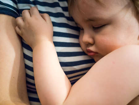 cute sleeping baby boy on mothers hands