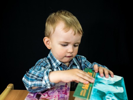 little baby boy hold book. Studio photo with black backgroundの写真素材