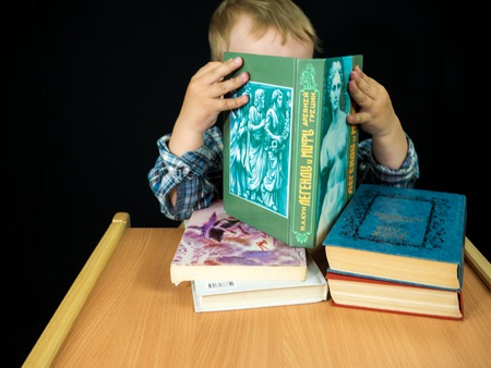 little baby boy hold book. Studio photo with black backgroundの写真素材
