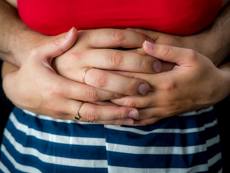 couple holding hands on black background. studio photoの写真素材