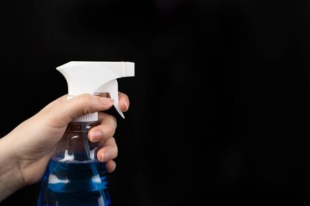 A product designed to clean surfaces and disinfect hands. The spray is used to clean the surfaces of objects and destroy microbes, bacteria and viruses. Composition on a dark backgroundの写真素材
