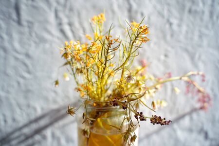 Abstract yellow bouquet of wildflowers on a vintage textured color background. The concept for that...