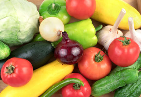 Washed fresh vegetables: tomatoes, cucumbers, zucchini and peppers in large quantities on a white background with water drops. Food background, top view. The concept of natural products.の写真素材
