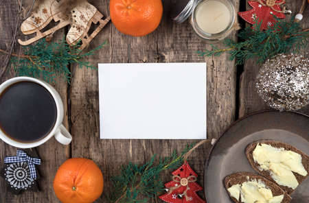 Tangerines, coniferous branches, Christmas trees, a Cup of coffee and sandwiches on a natural wooden background. Cozy Christmas composition. The concept of New year and Christmas.の写真素材