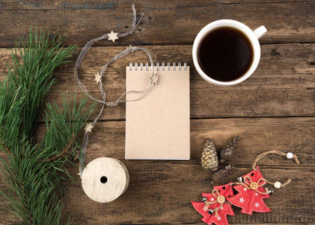 Christmas layout of a coffee Cup, Notepad, spruce branch and Christmas toys. Holiday background, top view and copy space. The concept of New year and Christmas.の写真素材