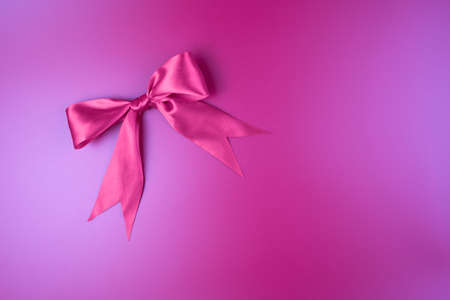 Pink beautiful bow on a gradient blue-pink background. Romantic background. Greeting card concept.の写真素材