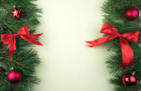 Christmas frame with pine branches decorated with red toys, bows on a concrete salad background. Holiday background with a place to copy, top view. The concept of Christmas, new year 2021.の写真素材