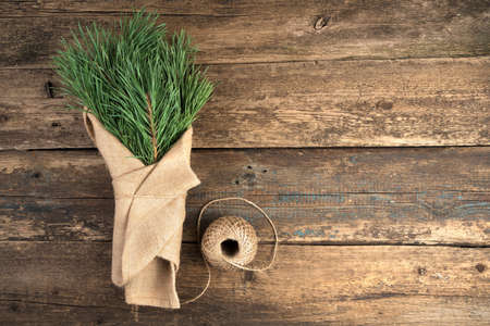 Bouquet with fir branches on a natural wooden background. The view from the top. The concept of New year and Christmas.の写真素材