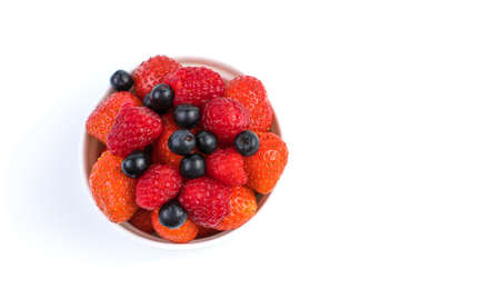Fresh strawberries, raspberries, Rowan in a Cup on a light background. Berry background top view,...