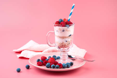 Berries and curd dessert with a glass on a pink background. Side view. Concept of product backgrounds.の写真素材