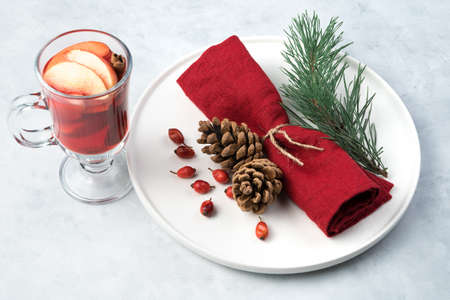 Happy New year and merry Christmas, festive background with decorated plate and fruit tea on light concrete background. Horizontal orientation, side view.の写真素材