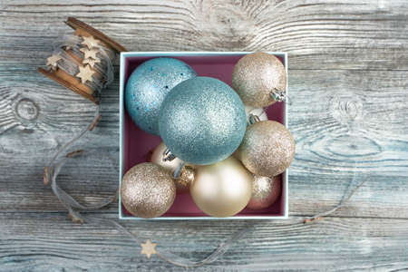 Many different Christmas balls and a ribbon with stars on a wooden gray background. The view from...