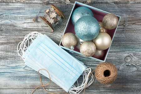 Protective masks lie next to a box of Christmas balls. Holiday background. The concept of...