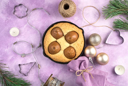 Christmas homemade pear pie with Christmas tree toys and candles on  pink
