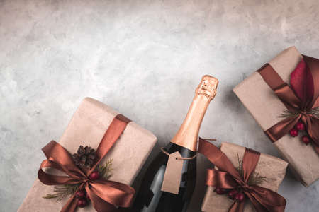 Gifts and champagne on a gray background. Top view with space to copy. The concept of New year and...