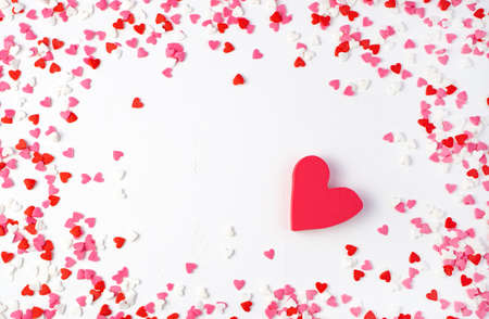 Red heart surrounded by small hearts on a light background. Top view, with space to copy. The...