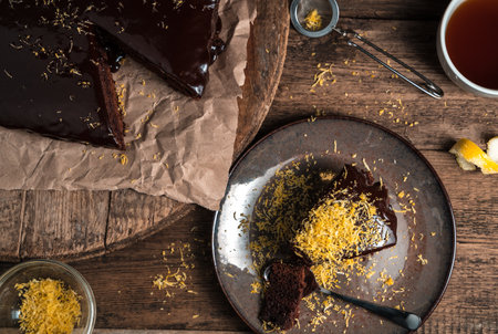 Chocolate brownie pie with lemon shavings on a wooden background. The view from the top. Concept of culinary backgrounds.の写真素材