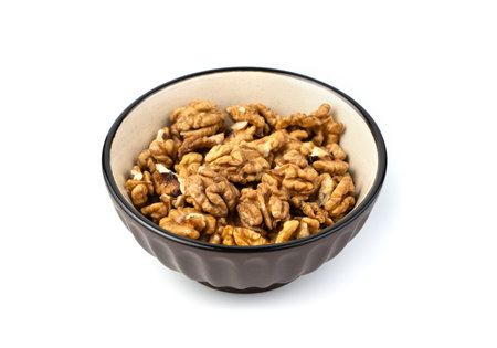 Walnuts in a brown plate on a white background. The concept of useful products.の写真素材