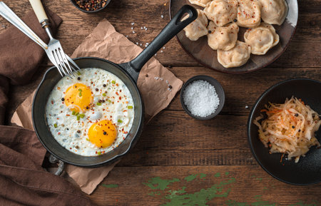 Scrambled eggs and dumplings on a wooden background. The view from the top. The concept of cooking.の写真素材