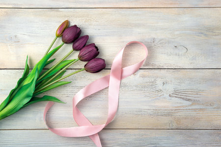 8 of ribbon and a bouquet of tulips on a light background. Top view with space to copy. The concept of holidays, International Womens Day.の写真素材