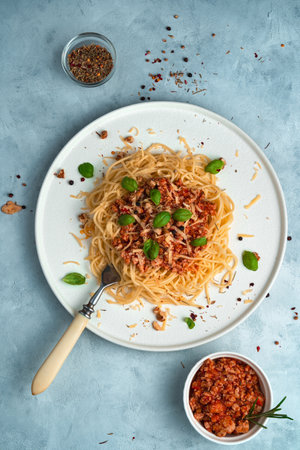 Pasta with thick sauce on a gray background. Top view, vertical orientation. The concept of a culinary background.の写真素材