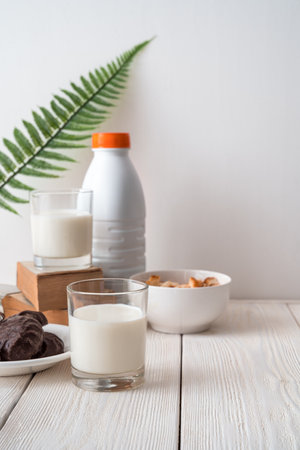 Breakfast with milk on a white background with a fern leaf. Side view, vertical orientation. The concept of food nutrition products.の写真素材