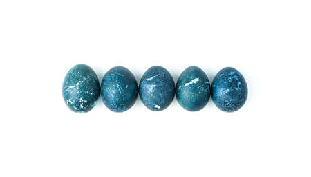 Five dark blue eggs are laid out in a row on a white background. Top view, horizontal.の写真素材