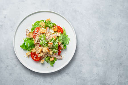 Classic Caesar salad with chicken breast on a gray background. Top view with copy space. Healthy food.の写真素材